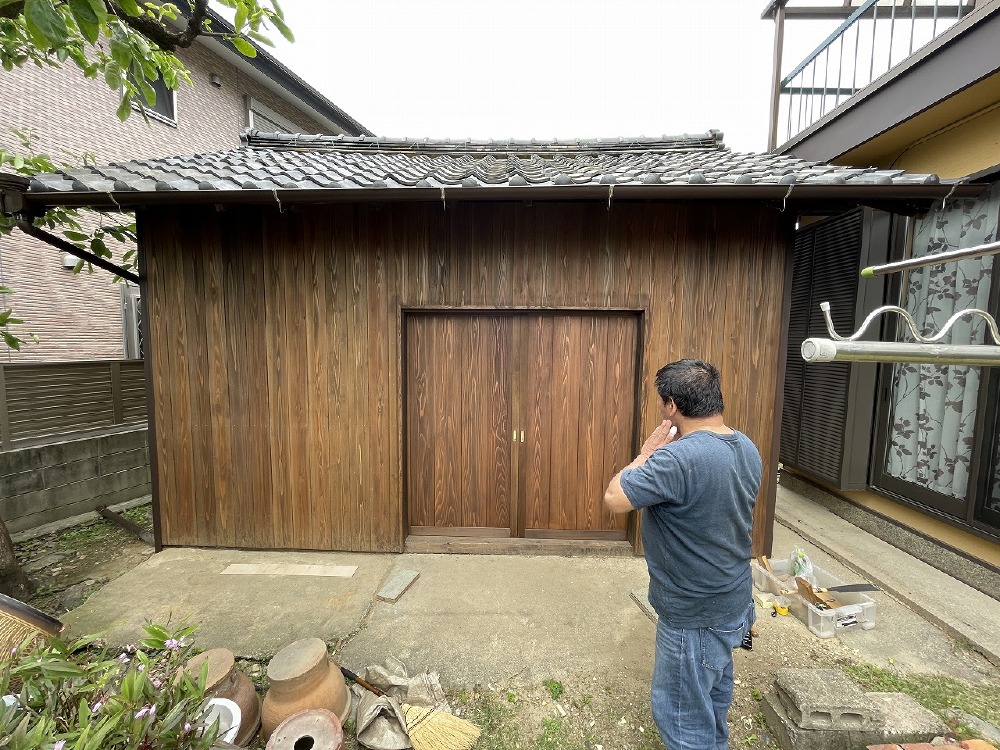 外壁と同じ杉板板目の板戸を取付ける 長瀬さん。  バッチリ納まりました（白井）