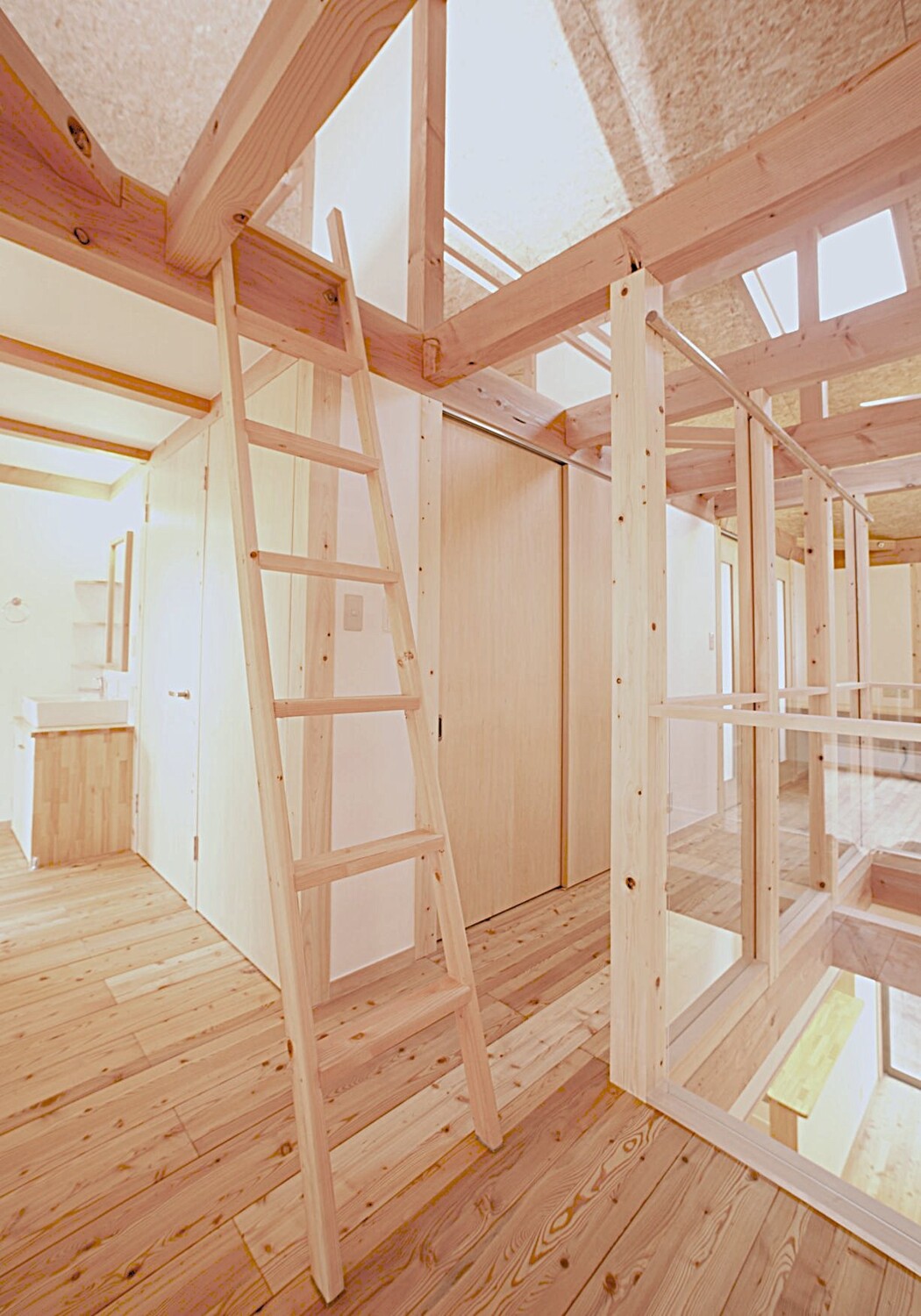 天窓から自然光が降り注ぐ明るい木造住宅の内部空間。