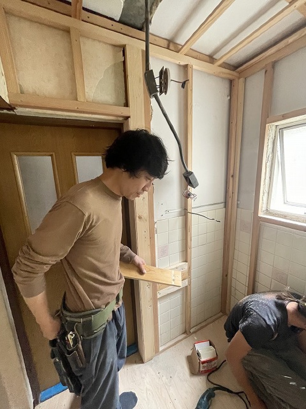 （天白区・T様邸・トイレ改装工事）寺やんがカットし、颯太君が下地を固定していきます。 下地が木ではないので、振動ドリルを使用、手間がかかります（白井）