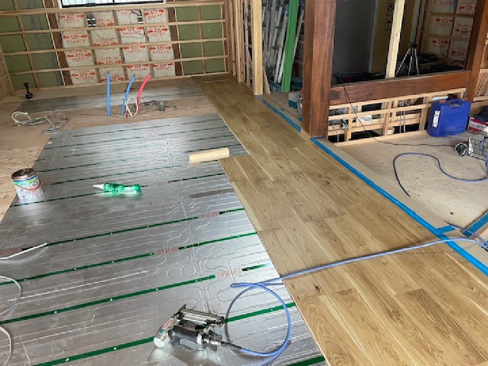 床暖房パネルの上に床材を貼り進めています