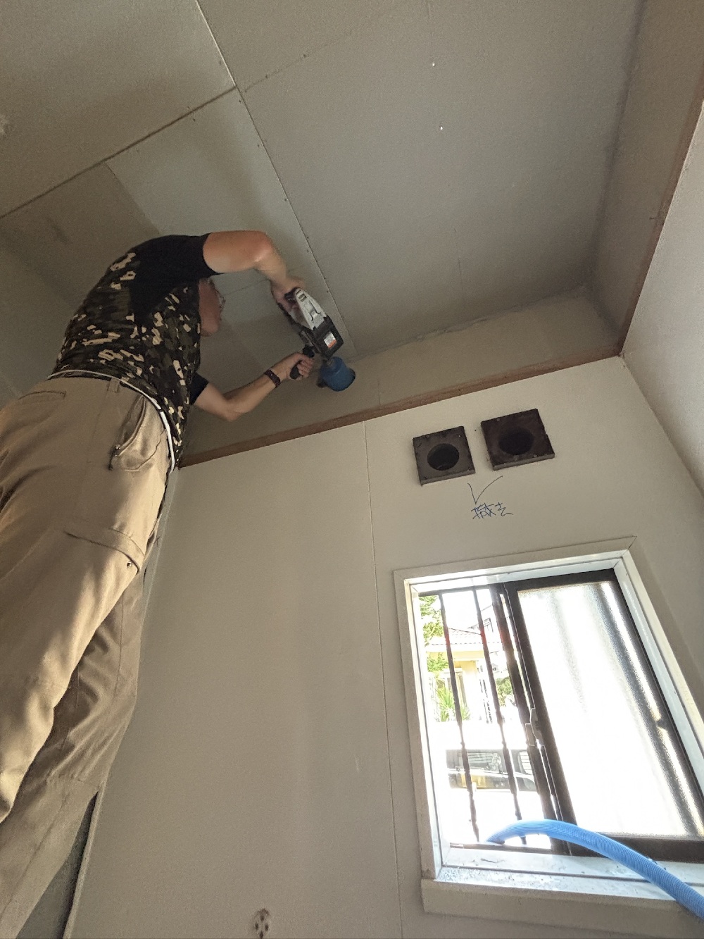お風呂に換気扇をつけるための穴開けをしています