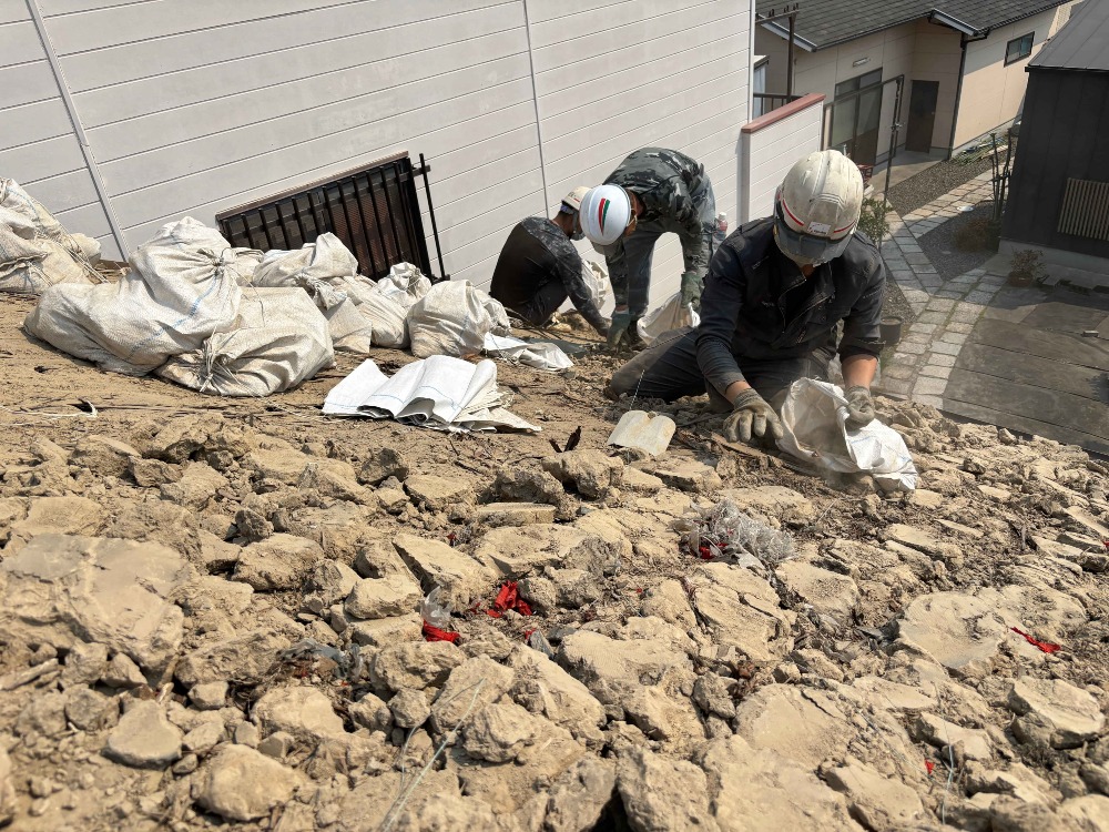 瓦下ろし作業が終わり、 葺き土を一つ一つ土嚢袋に詰めていきます