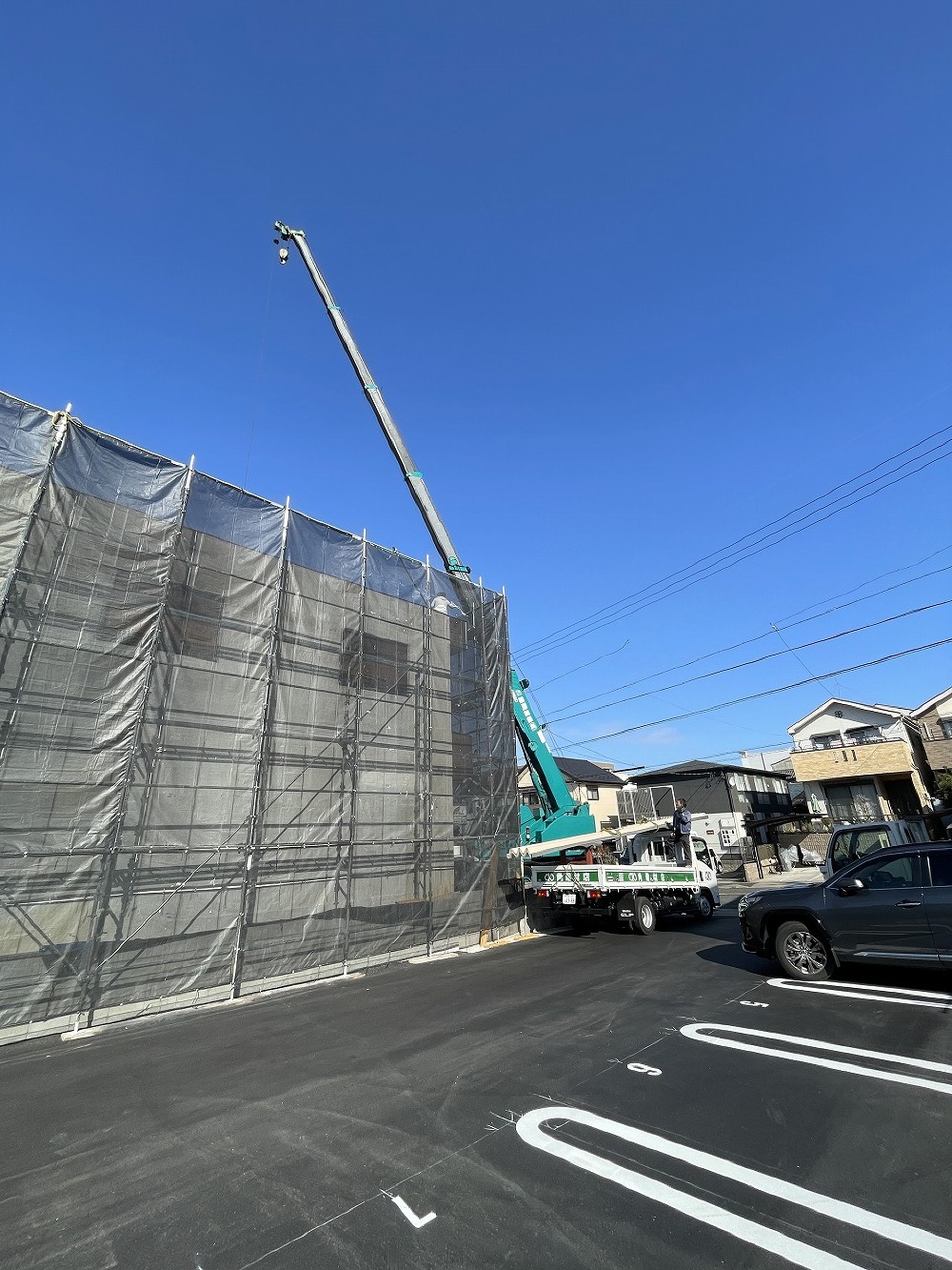 クレーン車を使って、長尺の屋根材を上げ、無事に荷揚げを完了しました。（白井）