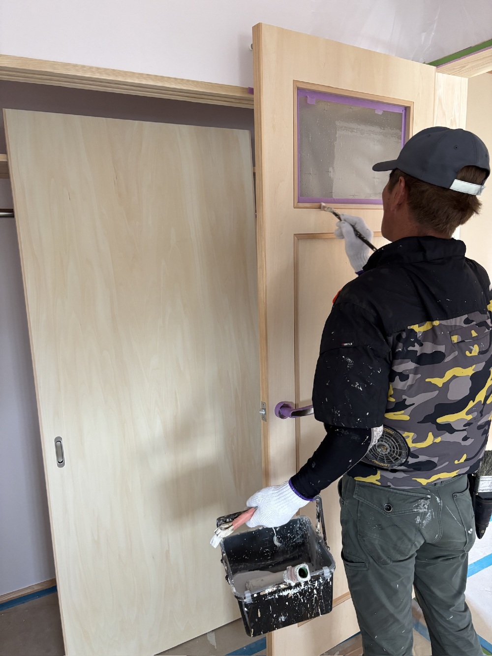 今日から建具の塗装に取り掛かっています 柿渋のホワイトを塗るカワワキさん