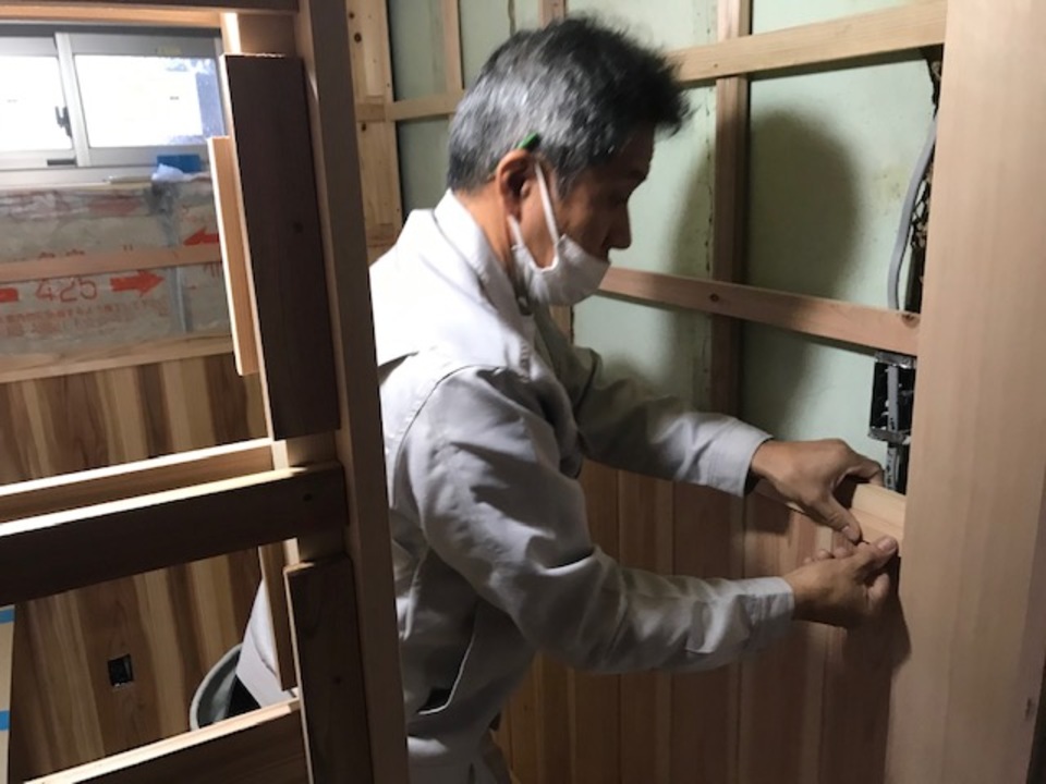 トイレの腰板を施工中の西川さんです（寺西）