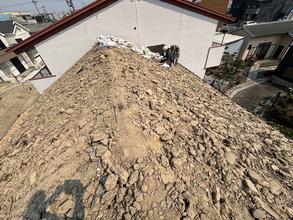 瓦下ろし作業が終わり、 葺き土を一つ一つ土嚢袋に詰めていきます