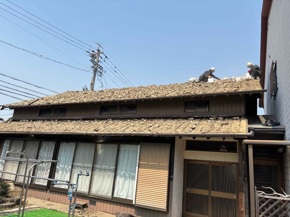 瓦下ろし作業が終わり、 葺き土を一つ一つ土嚢袋に詰めていきます