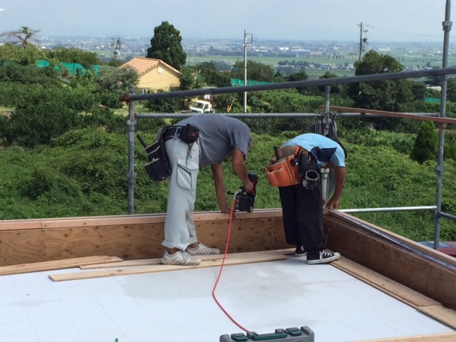 寺西です、おおきなバルコニーに合板を施工しています。