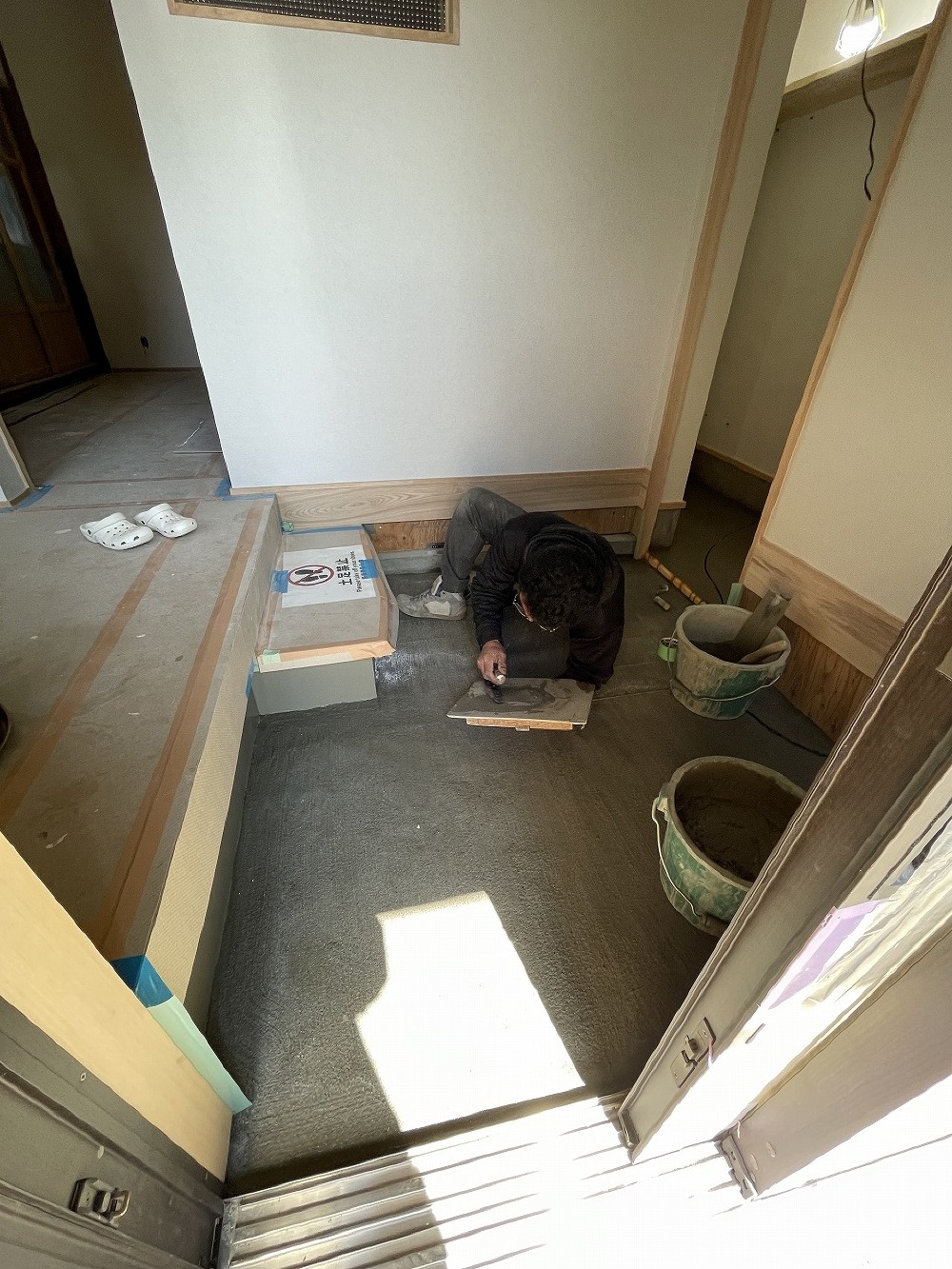 玄関部は仕上げの段取りする間瀬左官さん。 狭い所、ありがとうございます（白井）