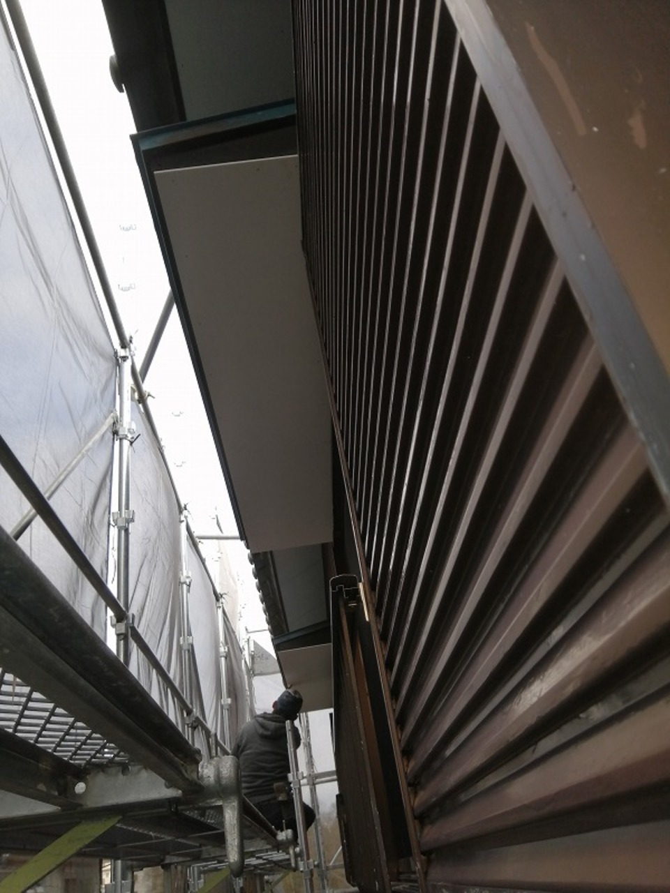 建物西面のケイカル板が張り終わり、川脇塗装さんが、丁寧にパテ打ち作業を進めています（寺尾）