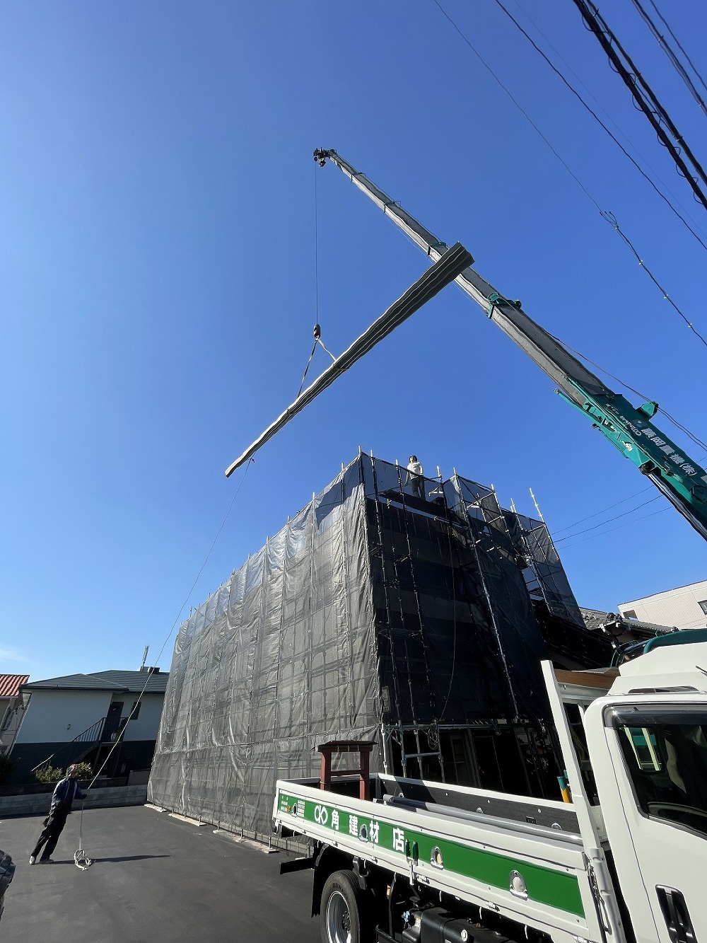 クレーン車を使って、長尺の屋根材を上げ、無事に荷揚げを完了しました。（白井）