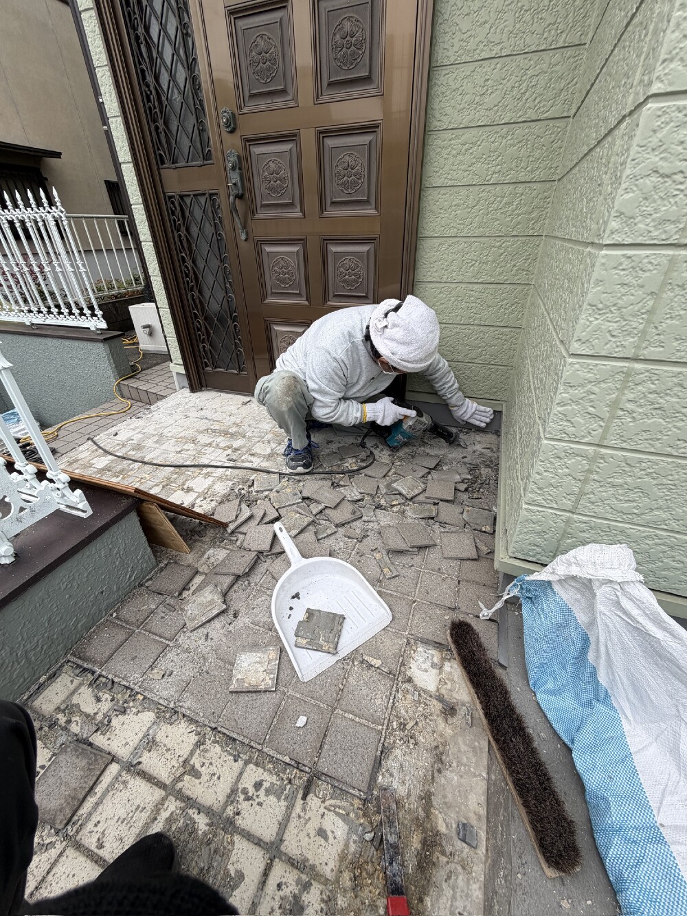 玄関ポーチタイルの貼替工事。浮いた既設タイルを斫っていきます