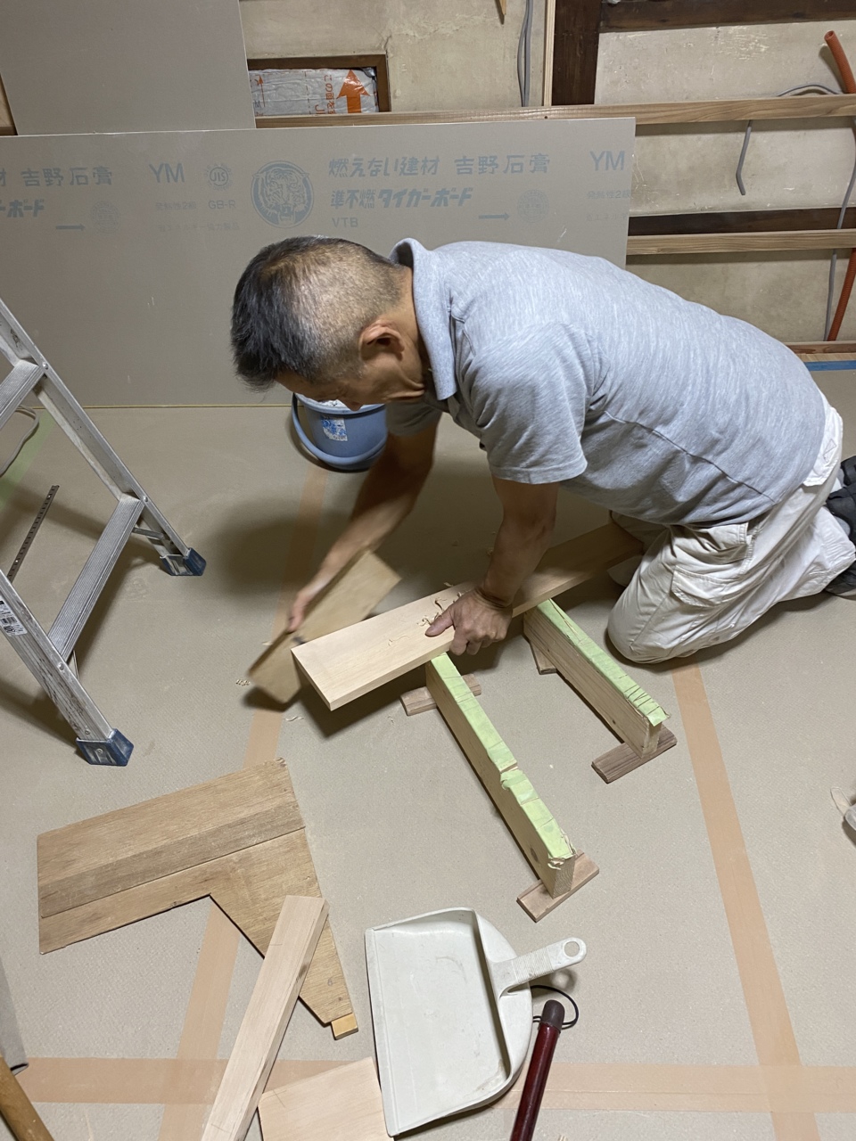 鉋で丸太に合わせて内法材を加工する西さん 既設丸太をしゃくり、建具の内法を造る仕事も終了