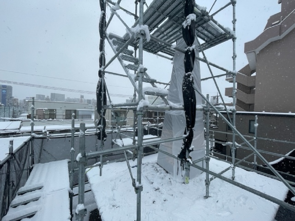 雪の中、塔屋根養生中（寺西）