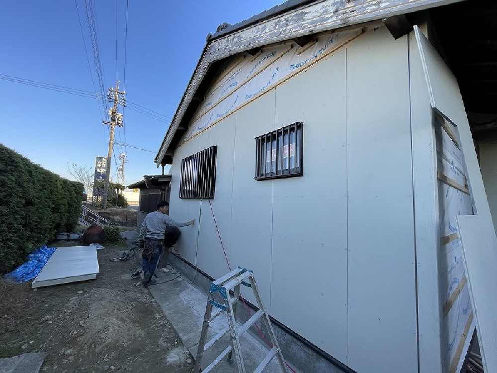 サイディングを貼って行く山ちゃんと颯太君。  防音を考慮し北面はトタンではなくサイディングにしました。