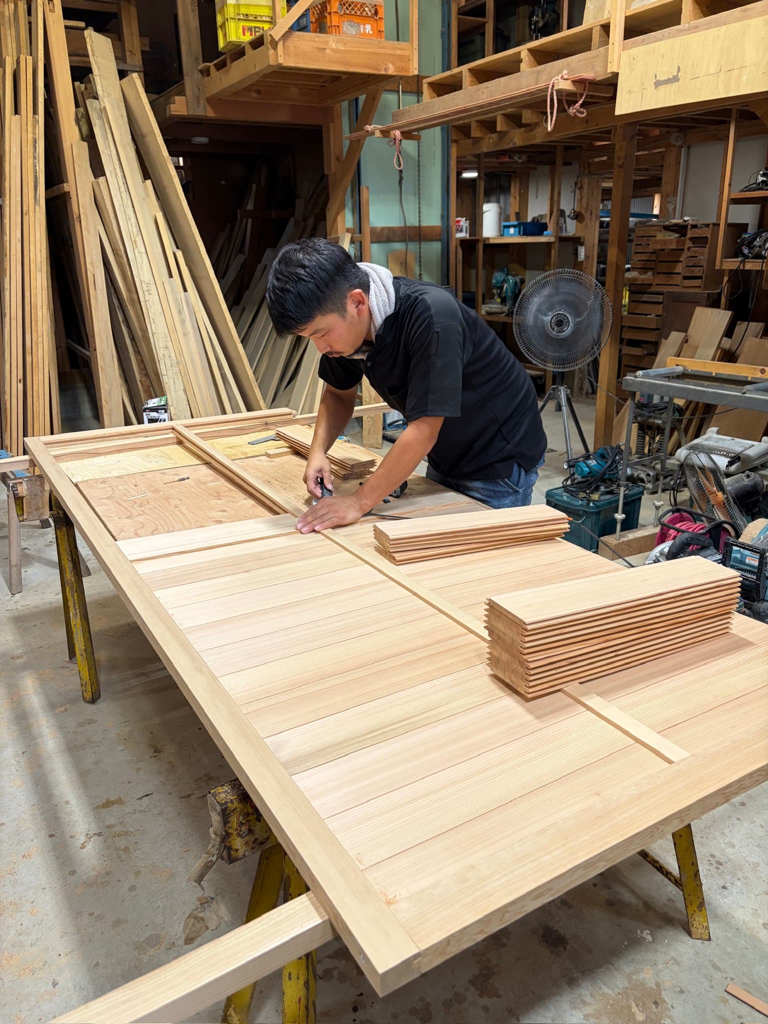 戸箱の鏡板を工場で製作する社員大工