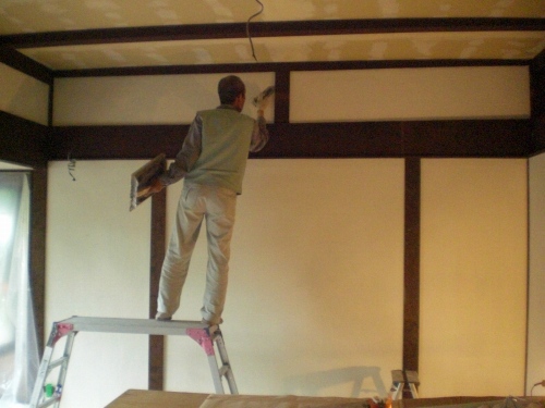 コテを返してしっくいを塗る左官屋のなべさん。知多市の古民家再生現場